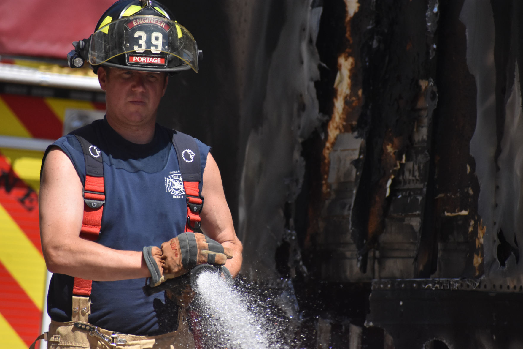 Matt Asch sprays wreckage with water hose